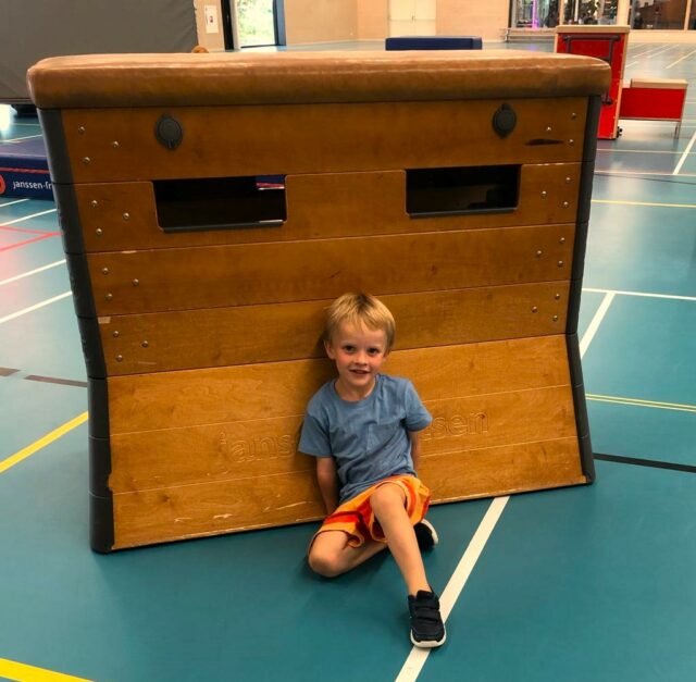 kind verstopt achter kast