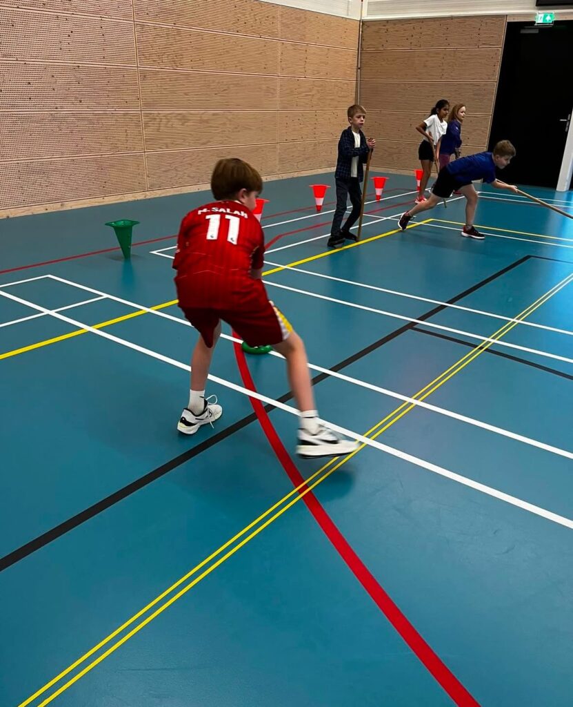 Kind speelt hockey bij Sport-BSO Flekss