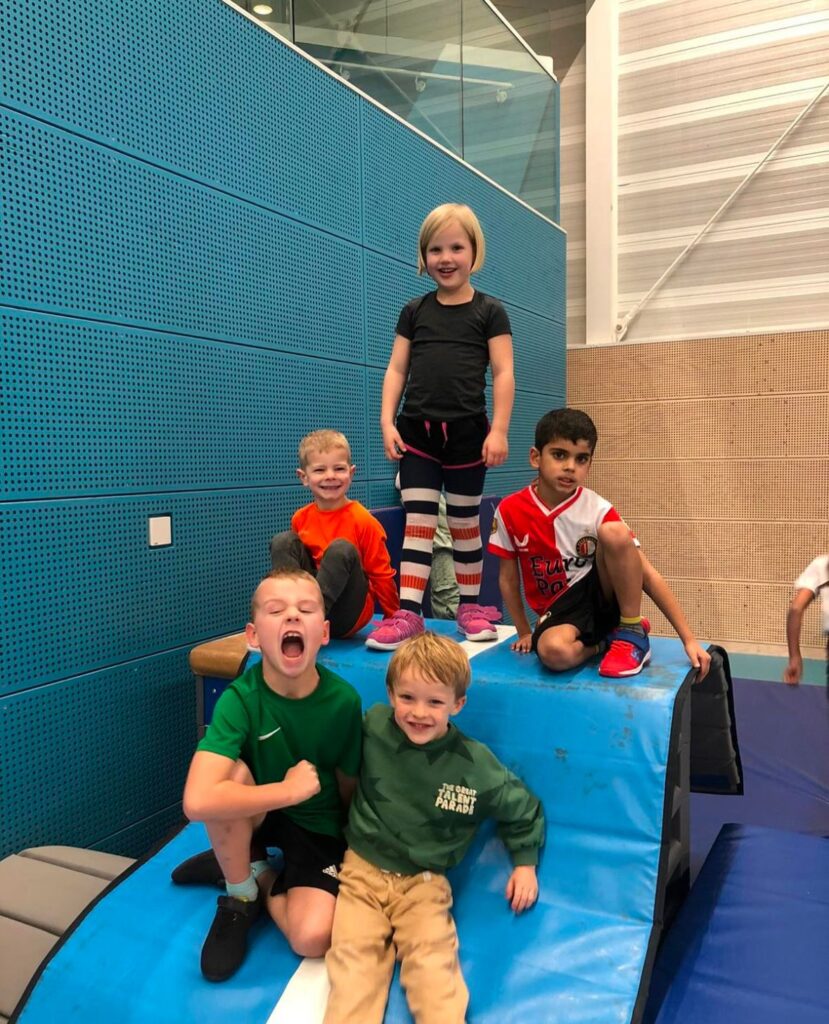 Kinderen spelen in gymzaal bij Sport-BSO Flekss