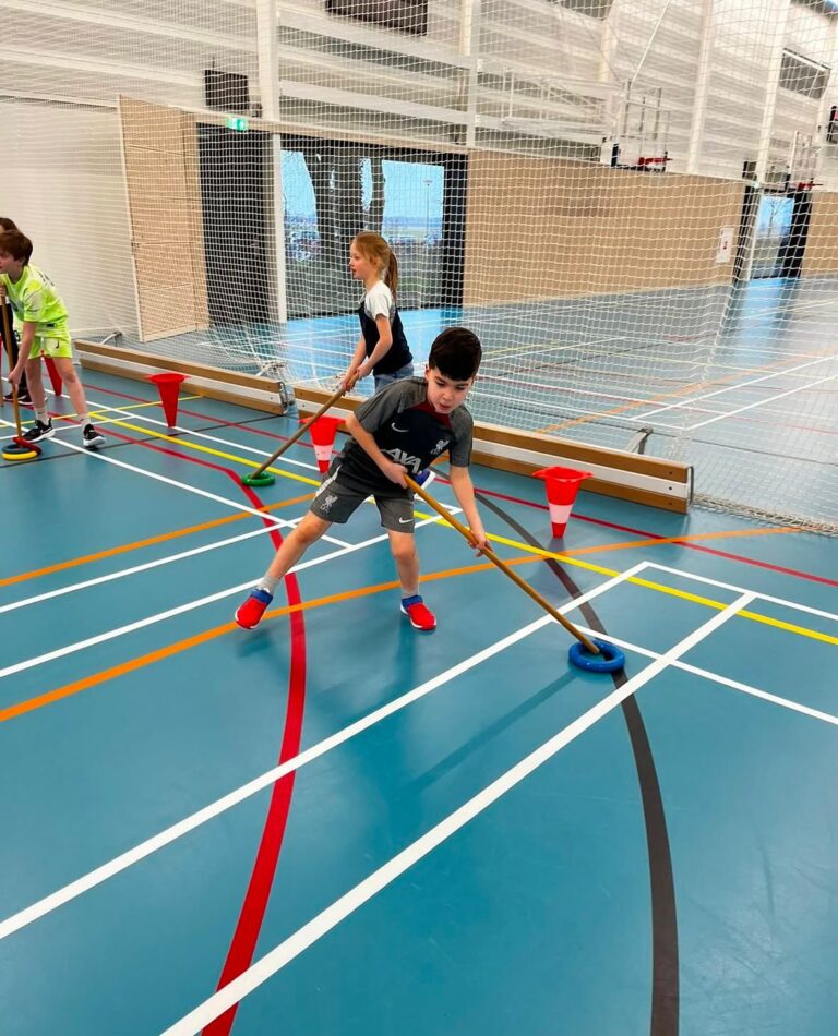 Kinderen spelen ringhockey bij Sport-BSO Flekss