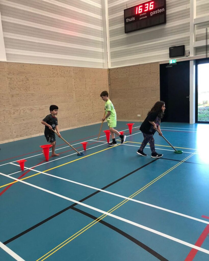Kinderen spelen Ringhockey bij Sport-BSO Flekss