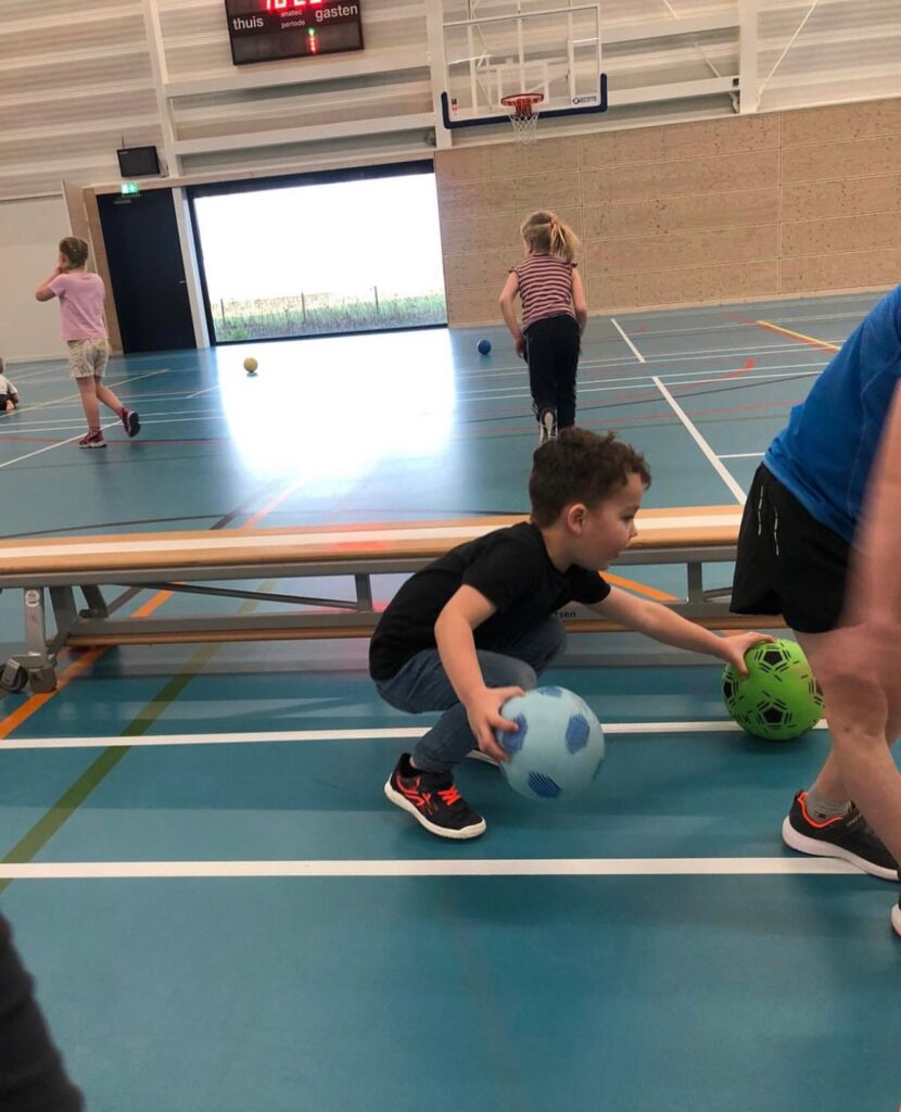Kinderen verzamelen ballen bij Sport-BSO Flekss