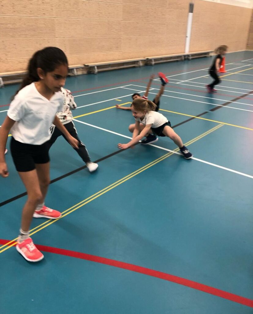 Kinderen spelen in de gymzaal bij Sport-BSO Flekss