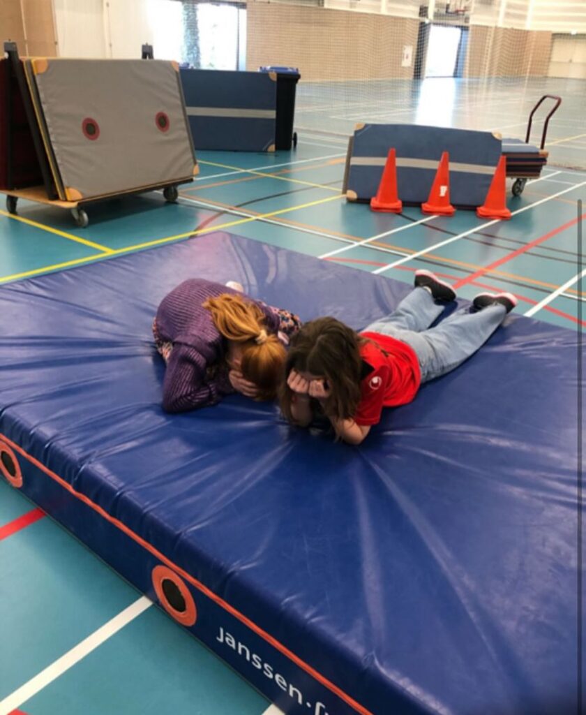 Kinderen zoeken tijdens verstoppertje bij Sport-BSO Flekss