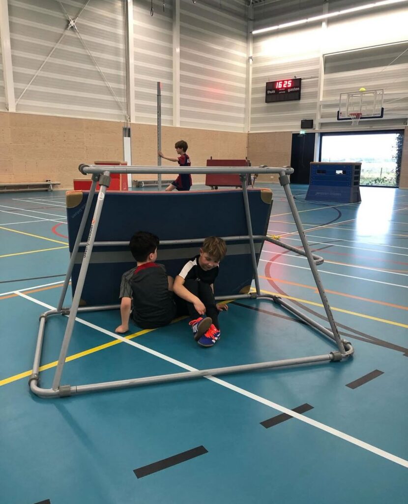 Kinderen verstoppen voor de zoeker bij Sport-BSO Flekss