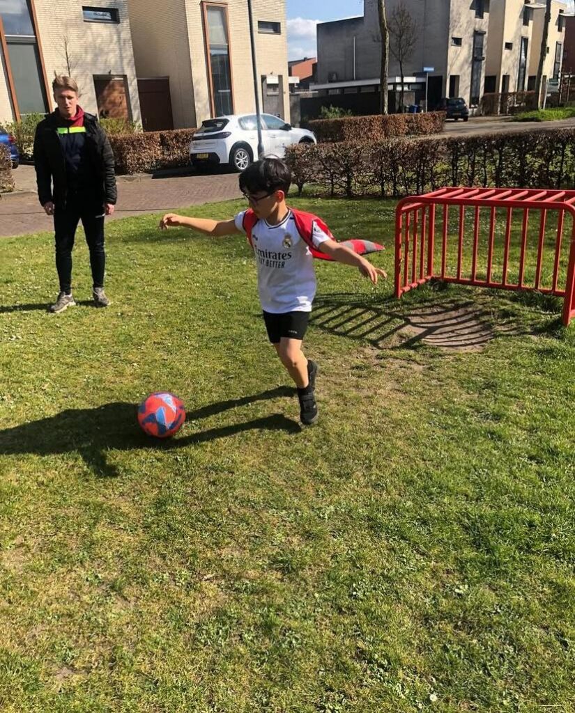 Kind is aan het voetballen bij Sport-BSO Flekss