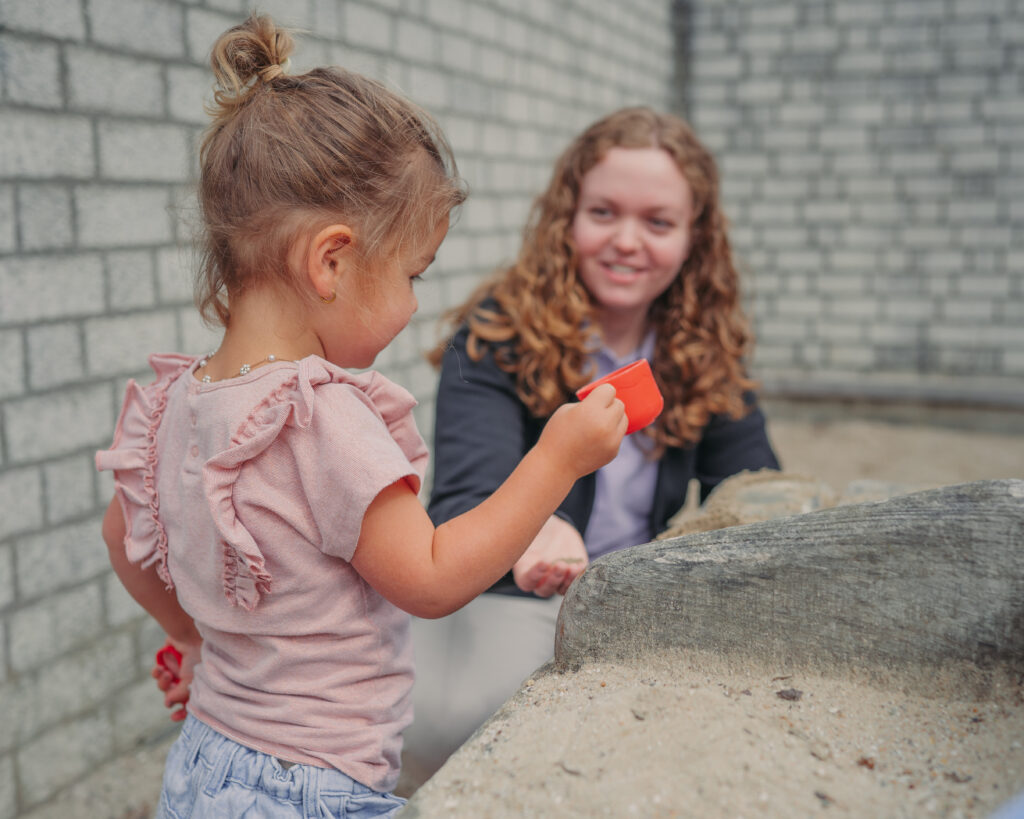 Medewerker Flekss speelt buiten met peuter