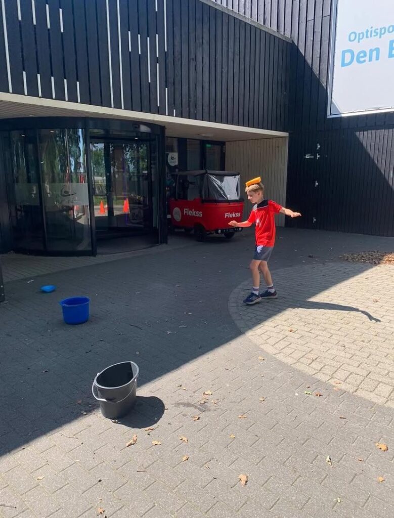 Kinderen spelen waterspelletjes bij Sport-BSO Flekss