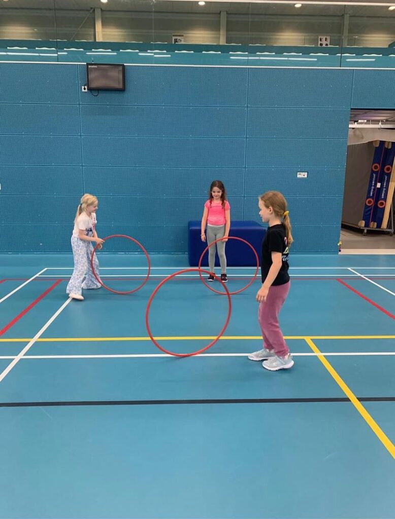 Kinderen spelen met hoepels bij Sport-BSO Flekss