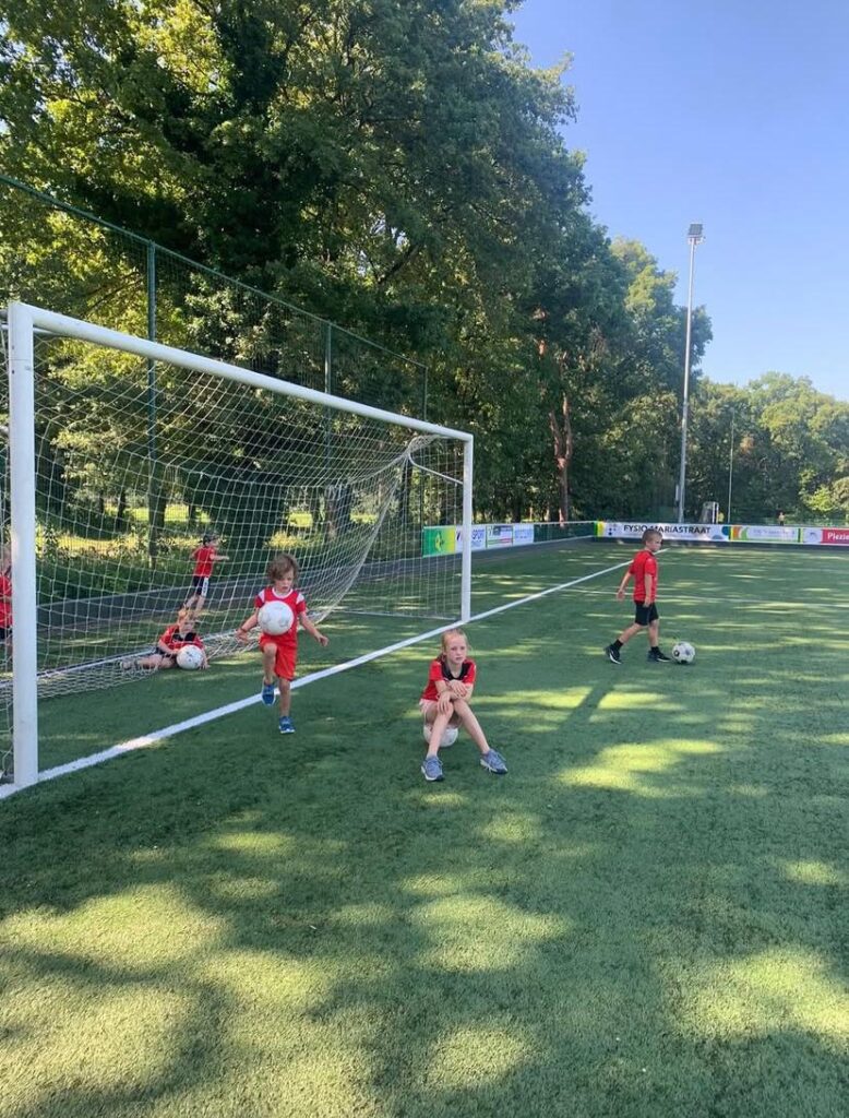 Kinderen spelen op het voetbalveld bij Sport-BSO Flekss