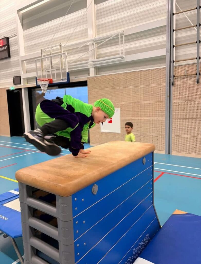 Kind springt over kast bij Sport-BSO Flekss