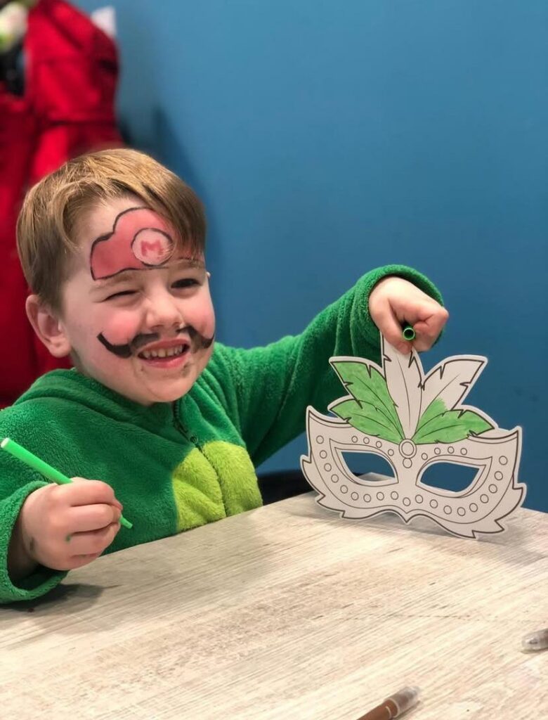 Kinderen versieren maskers bij Sport-BSO Flekss