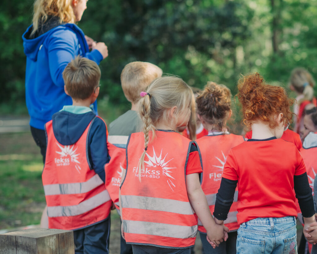 Kinderen van Flekss BSO Breda wandelen samen tijdens een buitenactiviteit