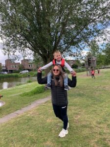 kind zit op de nek van de juf tijdens buiten spelen