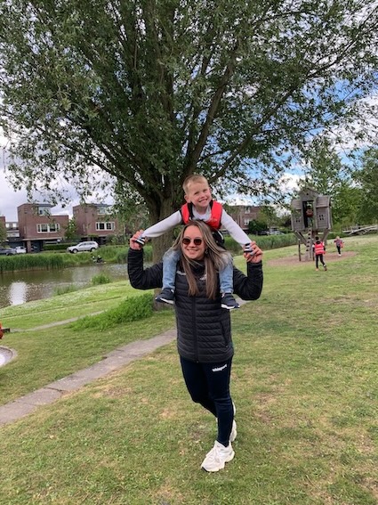 kind zit op de nek van de juf tijdens buiten spelen