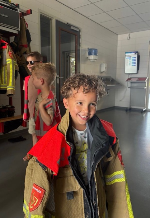 kindje heeft een brandweerjas aan