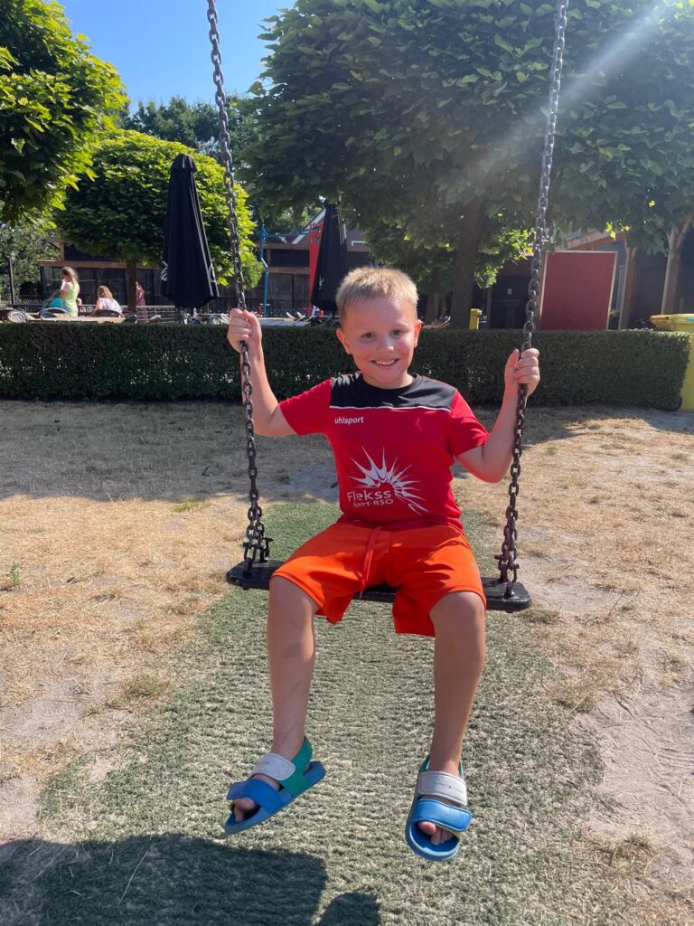 Kind zit op schommel