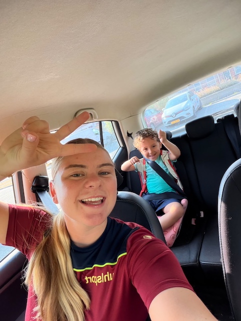 juf en kindje samen lachend in de auto