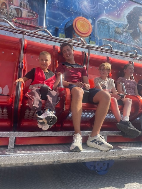 kinderen samen met de meester bij de kermis