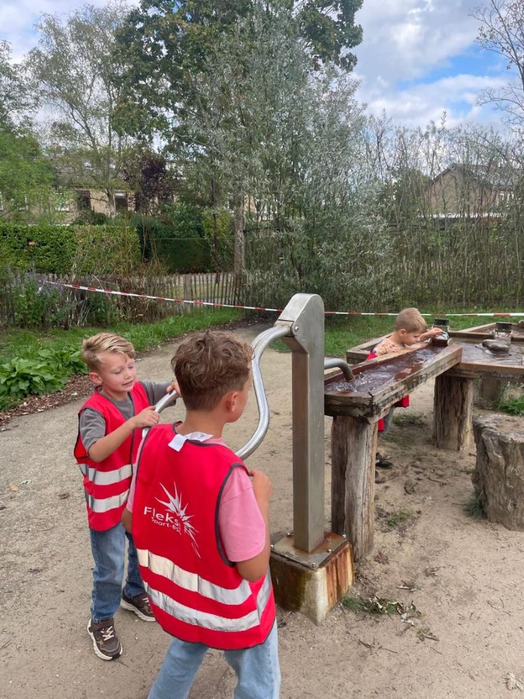 kinderen spelen met waterpomp
